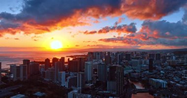Alacakaranlıkta Waikiki Panoraması. Çarpıcı renkli bulutlar manzaranın üzerindedir. Pasifik Okyanusu 'nun üzerinde parlak güneş batıyor. Hava görünümü.