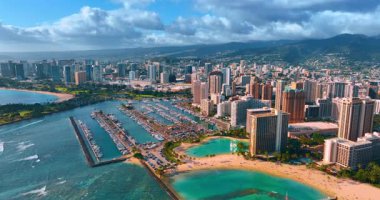 Bulutlu gökyüzünün altında Honolulu, Hawaii, ABD 'nin nefes kesici manzarası. İHA görüntüleri Waikiki ve büyük yat kulübünün kumlu sahiline yaklaşıyor..