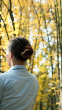 Park yerinde dinlenen bir kadın. Mutlu çekici kadın güneşli sonbahar parkında dinleniyor.