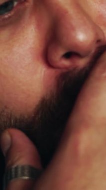 Elinde puro tutan bir adam. Genç sakallı adam stüdyoda sigara içiyor ve poz veriyor.