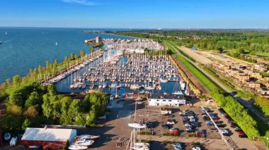 Merkemeer Gölü 'nün rıhtımında sayısız yat var. Yat kulübü ve Hollanda, Lelystad 'ın yeşil manzarasına hava perspektifi.