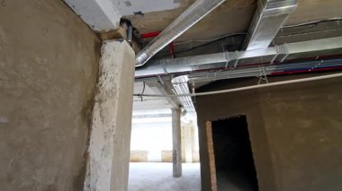 Binanın tavanındaki borular ve izole kablolar. İnşaat alanının iç kesimlerinde bir tur..