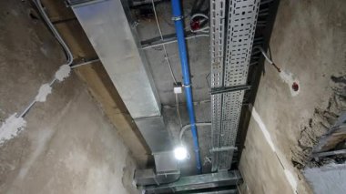 Uzun koridorun tavanında yeni elektrik ve havalandırma sistemi var. Düşük açı. İnşaat konsepti.