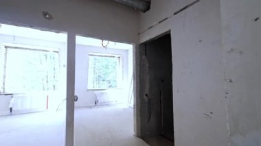 Binanın içinde inşa ediliyor. Çıplak duvarlara, kapılara ve tavandaki borulara bak..