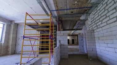 İnşaat binasının içindeki iskele iskelesi. İç kısımda yeni yapılmış beyaz tuğla duvarlar..