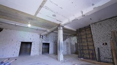 İnsanoğlu inşaatın büyük dayanağına girer. Ampul tavanda asılı..