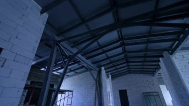 Beyaz tuğlalı duvarlar ve metal engellerle donatılmış. Yeni çatıda düşük açı görünümü.