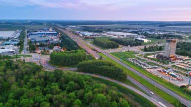 Alacakaranlıkta Hollanda otoyolu. Hollanda 'da yemyeşil ve alacakaranlık sırasında kentsel gelişimle çevrili bir otoyolun havadan görünüşü..