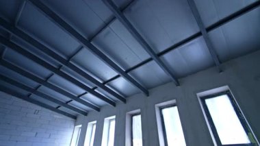 Modern tavan tasarımı. Şık tavan kirişleri ve geniş pencereli çağdaş bina inşaatı başlıyor..