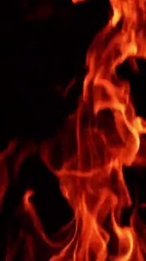 Şenlik ateşinin üst kısmı gece yanıyor. Yakından izole edilmiş tehlikeli bir alev. Dikey video