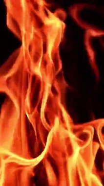 Karanlıkta çabalayan güzel bir ateş alevi. Siyah arka planda yanan şenlik ateşinin üst kısmı. Kapatın. Dikey video