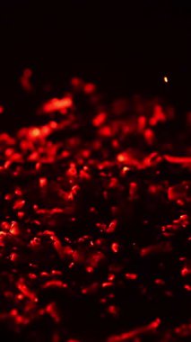 Yanan közlerde parlayan kırmızı ışık beliriyor. Kamp ateşi söndü ve kömür yanıp kül oldu. Kapatın. Siyah zemin. Dikey video