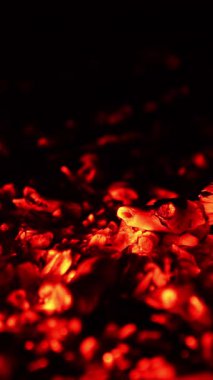 Ateşli, yakıcı, yanmış odun parçaları. Kömürün üzerine küçük bir alev sıçradı. Kapatın. Dikey video