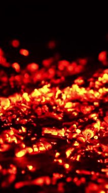 Yere saçılmış yanan kırmızı közler. Duman yükselir ve kömür rüzgardan yanıp söner. Kapatın. Dikey video