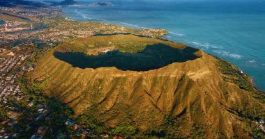 Parlak güneş ışığında muhteşem Diamond Head Krateri. Yeşil yerleşim alanı volkanik kayanın etrafındadır. Hava görünümü.