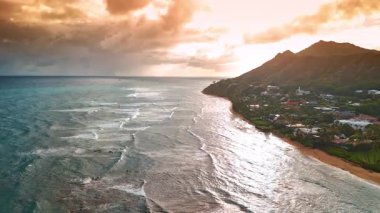Dalgalar Honolulu, Hawaii, ABD kıyılarına ulaşır. Gökyüzünde renkli turuncu bulutlar toplandı. Hava görünümü.