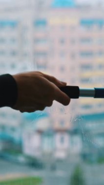 Profesyonel temizlik penceresi. Pencereyi özel ekipmanla temizleyen adam. Dikey video