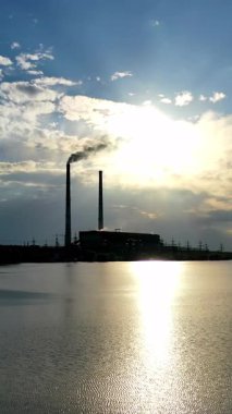 Fabrikanın gölgesinin havadan görünüşü. Gün batımında endüstriyel gölge. Dikey video