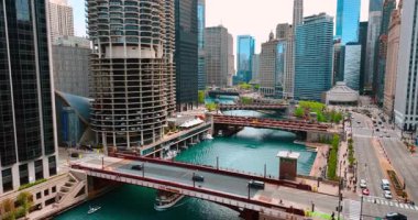 Arabalar Chicago Nehri üzerindeki köprünün yanından geçiyor. Motorlu tekne köprünün altından geçiyor. Chicago şehir merkezi, Illinois, ABD.