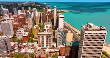 Michigan Gölü 'nün güneşli rıhtımında çeşitli mimari yapılarla yükseliyor. Lakeshore Drive 'dan bir sürü araba geçiyor..