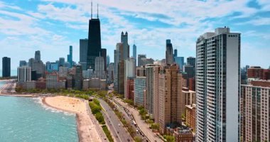 Lakeshore Drive 'da birden fazla aracın geçişini izleyin. Kumsalın yukarısında bir sürü insanla İHA uçuşu. Chicago 'nun gökdelenleri bulutlu gökyüzünün arka planında.