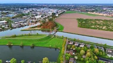 Hollanda 'nın sakin manzaralı kırsal kesimine. Kanallar üzerine kurulmuş güzel bir köy. Hava perspektifi.