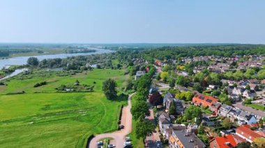 Dar bir nehrin rıhtımında rahat, resimli bir yerleşim yeri. Güneşli bir günde Hollanda 'nın kırsal kesiminin üzerinde uçuş.
