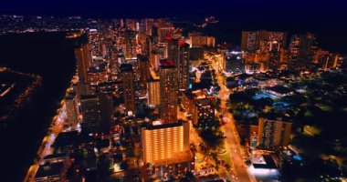 Muhteşem Waikiki, Hawaii, ABD 'nin ışıltılı manzarası üzerinde uçuyor. Geceleri modern şehrin göz kamaştırıcı lüks manzarası..