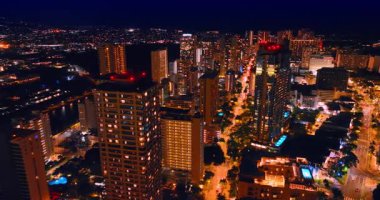 Waikiki 'nin aydınlık caddelerinde gece trafik yoğundu. Honolulu, Hawaii, ABD 'nin gece manzarası. Hava görünümü.