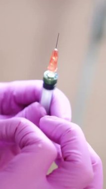 Enjeksiyon için şırınga hazırlayan kozmetikçinin elini kapat. Görüntü. El bilgisayarı gerçek zamanlı yakın çekim dikey video