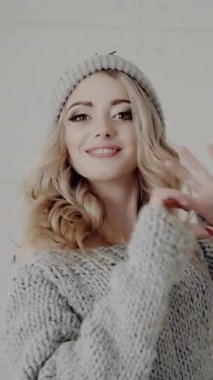 Örgü şapkalı mutlu kız kalbi gösteriyor. Sevgililer Günü. Dikey video