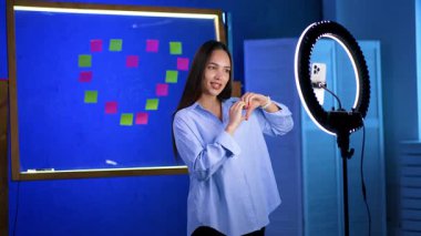 Beyaz bir bayanın blog çekmesi çok güzel. Kız halka ışığıyla kameraya konuşuyor. Video kaydeden blogger.