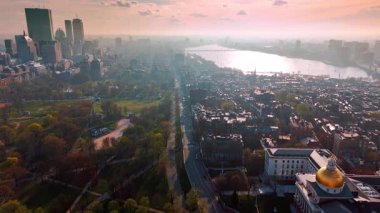 Modern Boston, Massachusetts, ABD 'nin puslu manzarası. Güneş metropolün panoramasını kamaştırıyor. İnsansız hava aracı araba dolu otoyollara iniyor..