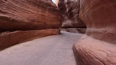 Koridor boyunca yürüyüp kayaların arasında rüzgarlar tarafından eğilmiş ve kesilmiş olarak yaratılmış. Petra, Güney Ürdün, Batı Asya 'ya giden muhteşem kumtaşı kayaları..