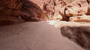 Yüzyıllar boyunca rüzgar gücüyle oyulmuş dik kumtaşı kayalıkları. Güney Ürdün 'de, Batı Asya' da, Petra 'daki Al Siq Kanyonu' nun kayaları arasında görüntüler. Düşük açı görünümü.