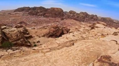 Kayanın tepesinden çekilen görüntüler kayalık araziyi göz kamaştırıcı kanyonlarla gösteriyor. Güneşli Ürdün, Batı Asya 'nın simgeleri.