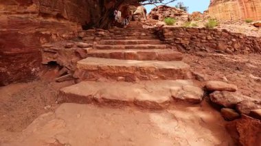Kanyonlardaki taş merdivenler. Bazı giysiler kuru ağaca bağlanmış ipe asılı. Büyüleyici Petra, Ürdün, Batı Asya 'da yürüyüş..