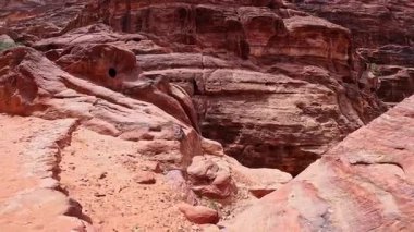 Çöldeki rüzgarın kavisli kırmızı kaya oluşumları. Kum taşlarına yükselen taş merdivenlere bakın. Petra, Ürdün, Batı Asya.