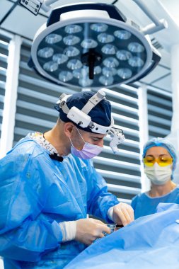 Karmaşık operasyonlarda cerrahlar. Cerrahlar modern bir ameliyathanede hassas bir prosedüre odaklanırlar. Takım çalışması ve hassasiyet gösterirler..