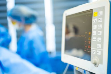 Ameliyatta hayati belirtileri takip ediyorum. Bir tıbbi uzman ameliyat odasındaki ameliyat sırasında hayati belirtileri monitörden izler..