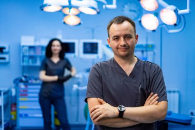 Cerrahlar ameliyata hazırlanıyor. İki tıp uzmanı, modern bir cerrahi odasında, prosedür için birlikte çalışmaya hazır bir şekilde duruyorlar..