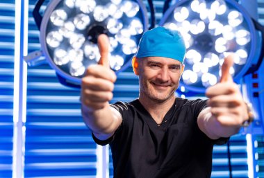 Cerrah başarıyı kutlar. Ameliyat sonrası önlüklü ve şapkalı bir cerrah, ameliyattan sonra heyecanını gösterir. Ameliyathanede iki parmağını kaldırır..