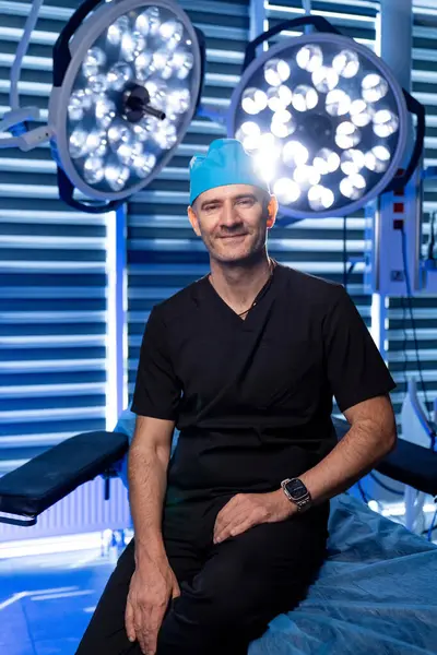 Ameliyathanede kendine güvenen bir cerrah. Yetenekli bir cerrah ameliyat masasında sakince oturur. İyi aydınlatılmış, modern bir tıbbi tesiste ameliyata hazırdır..