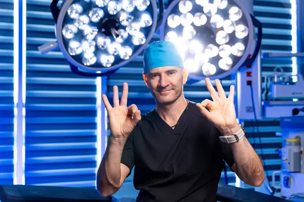 Cerrah ameliyathanede hazır. Önlüklü ve şapkalı kendine güvenen bir cerrah önemli bir ameliyata başlamadan önce onay veriyor..