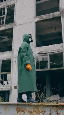 Özel radyoaktif üniformalı bir adam geliyor. Yeşil kimyasal elbise ve gaz maskesi takan adam. Dikey video