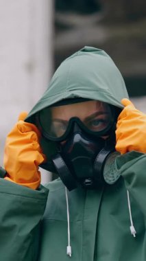 Maskeli ve tehlikeli madde uzmanı. Koruyucu maskeli bir kadına yaklaş. Apocalypsis şehri. Dikey video