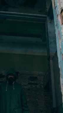 Koruyucu giysili ve gözlüklü adam. Koruyucu üniformalı bir insan tehlikeli bir şehre çiçek dikiyor. Dikey video