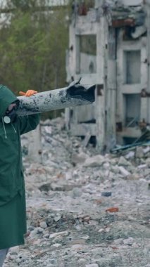 Sokakta yürüyen koruyucu üniformalı bir bilim adamı. Salgın takım elbiseli bir adam sokakta yürüyor. Dikey video