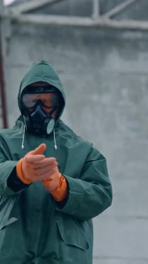 Koruyucu maskeli ve güvenlik tehlikesi olan bir adam. Koruyucu üniformayla karantina üzerinde çalışan bir bilim adamı. Dikey video