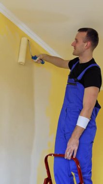 Genç bir boyacı evde yeni bir tadilat yapıyor. Boyacı evin içini renklendirerek dekore ediyor. Dikey video